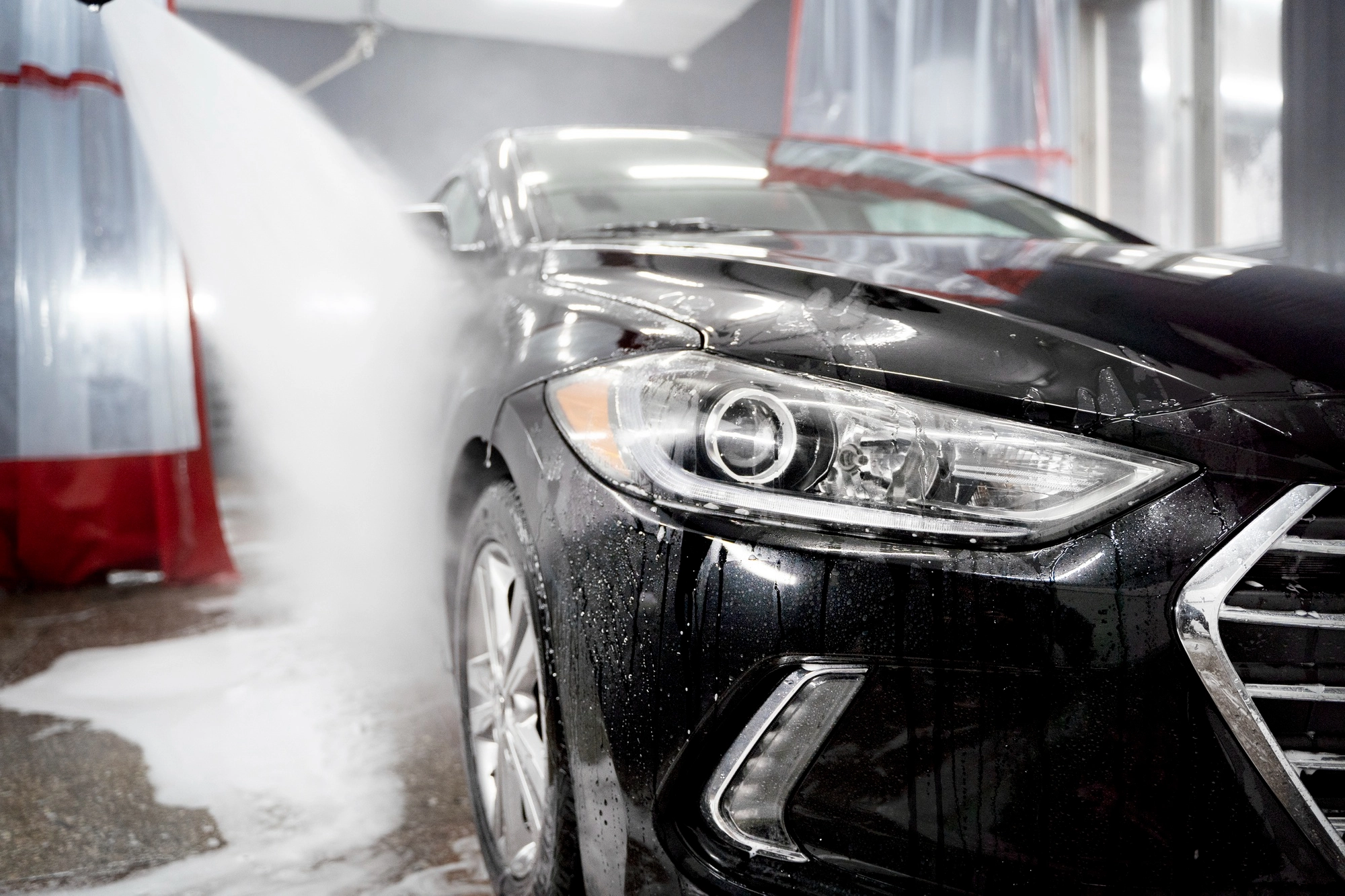 Swirl marks visible on dark car paint in sunlight